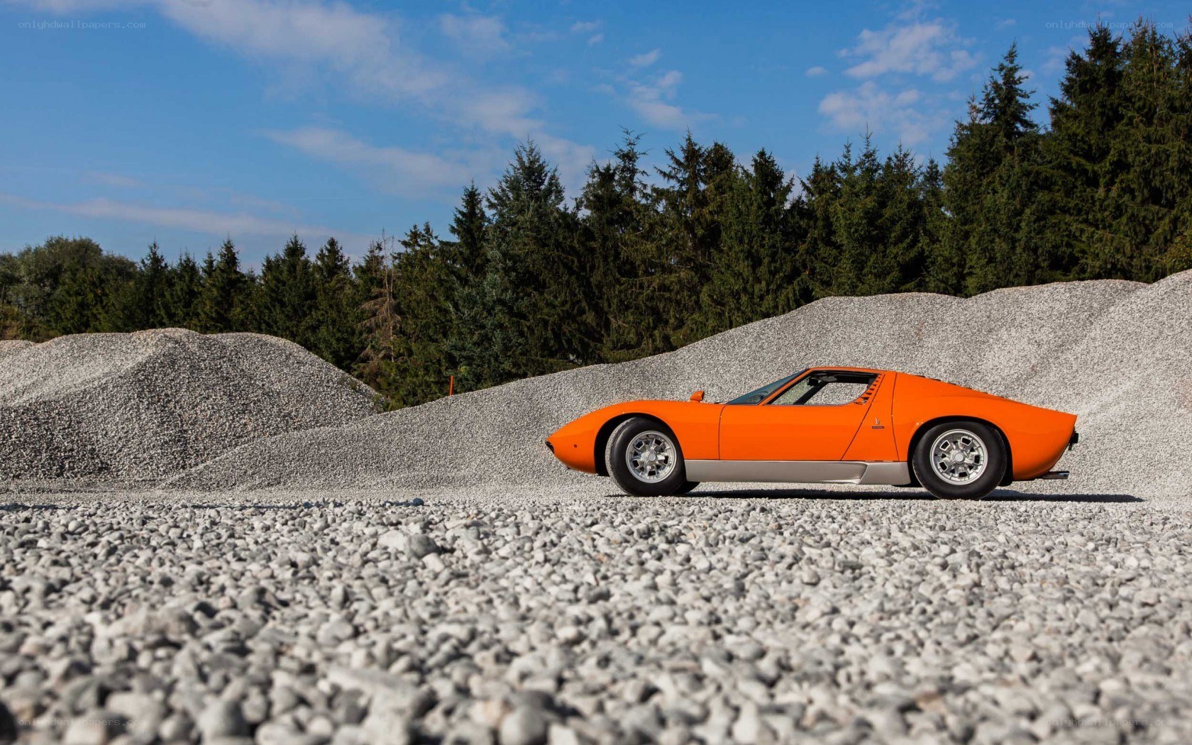 Orange sports car on gravel