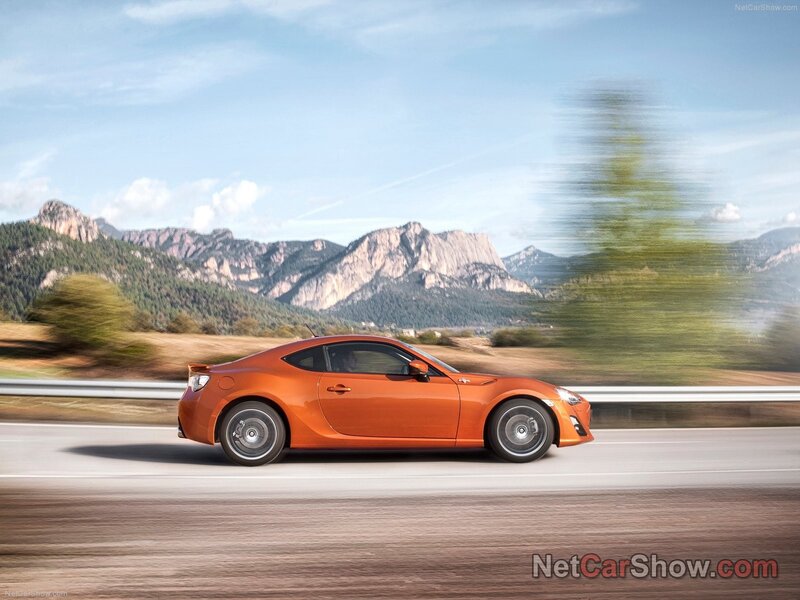 orange sports car on mountain road