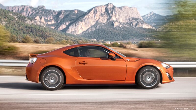 orange sports car on mountain road