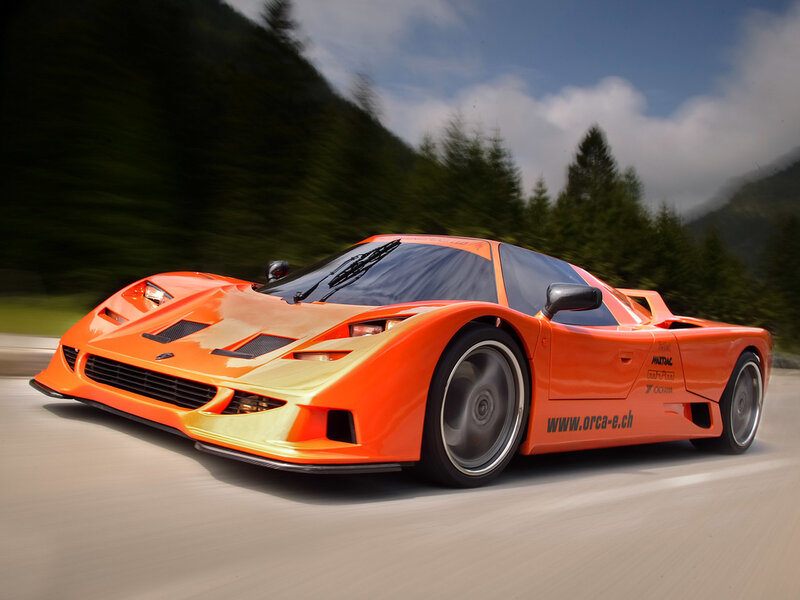 orange sports car on mountain road