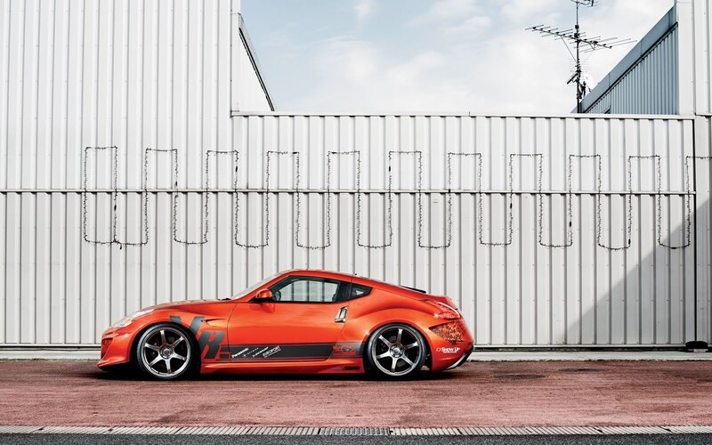 Orange sports car on red pavement
