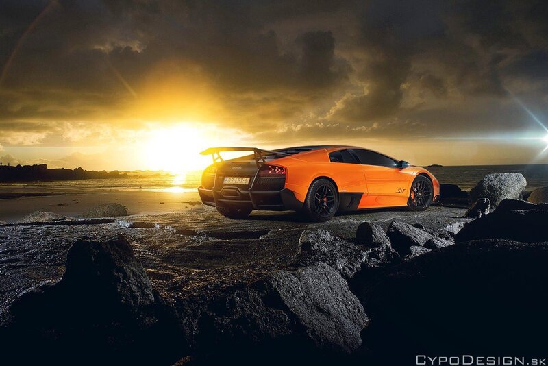 Orange sports car on rocky beach
