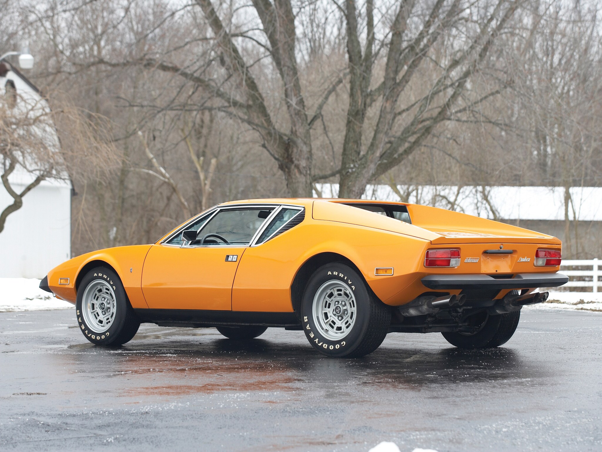 orange sports car on wet pavement