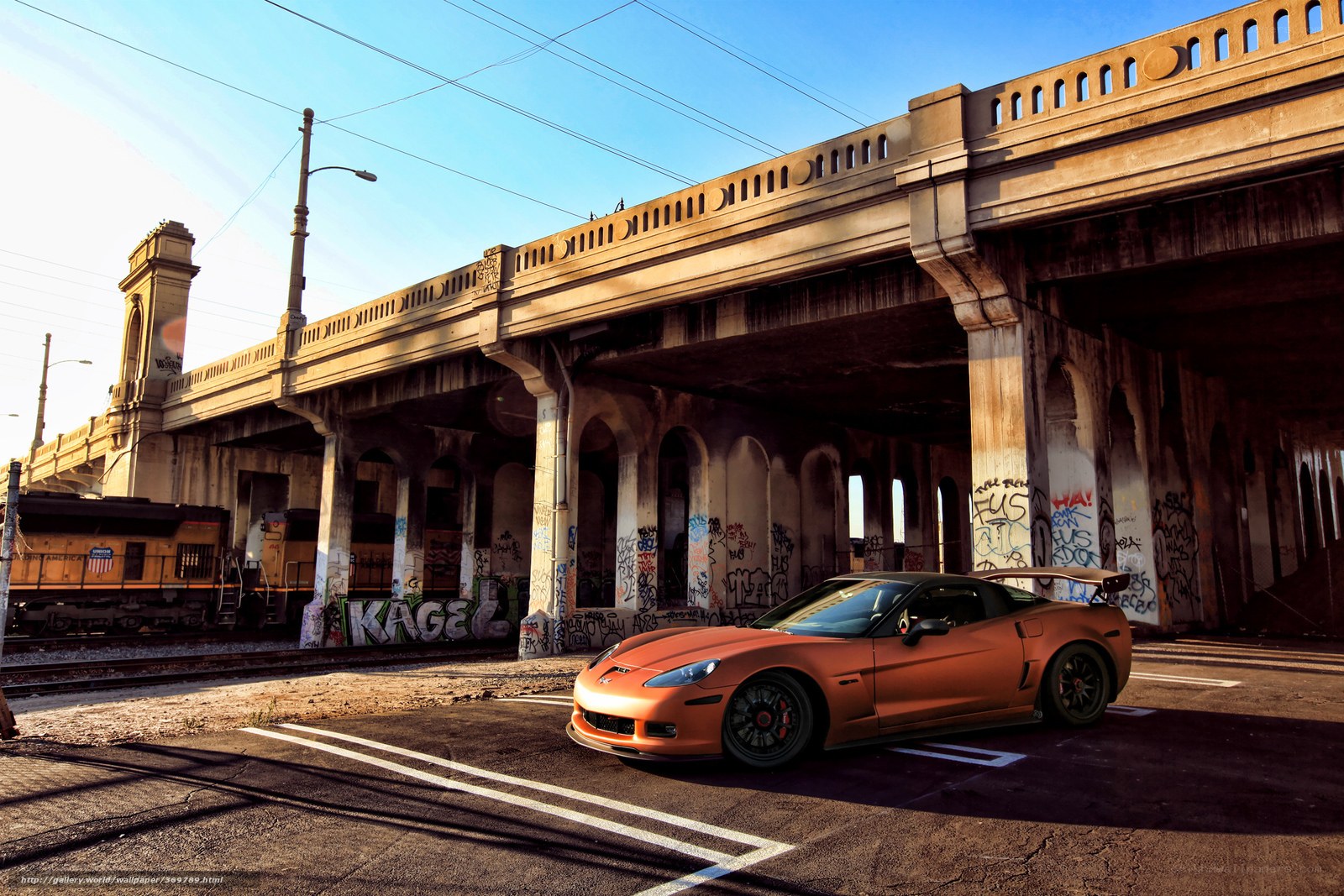 Orange sports car under a bridge