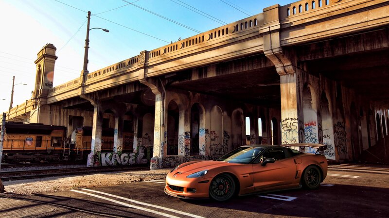 Orange sports car under a bridge