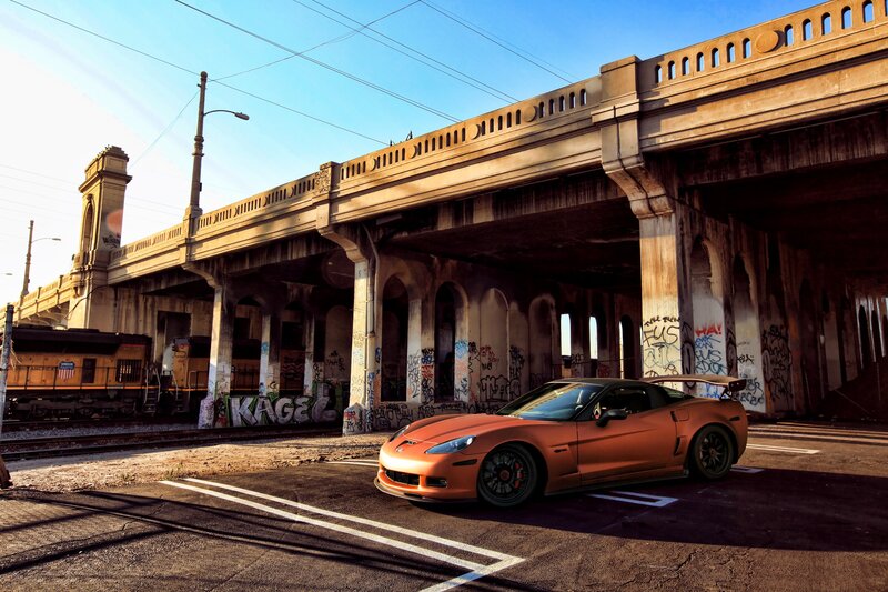 Orange sports car under a bridge