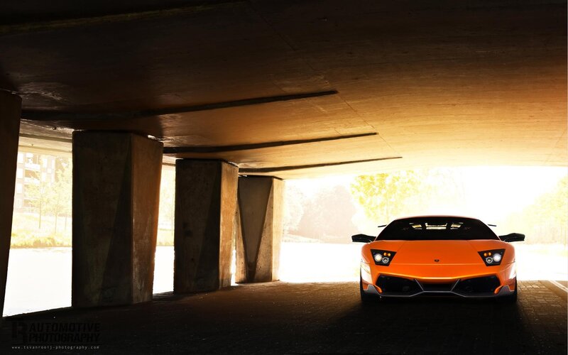 Orange sports car under bridge