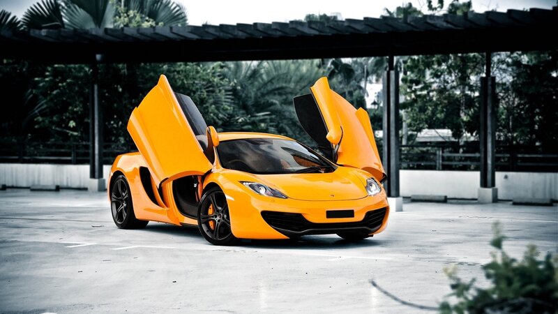 orange sports car with doors open