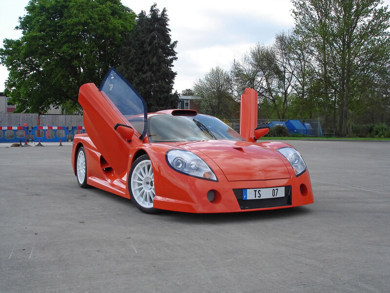orange sports car with doors open