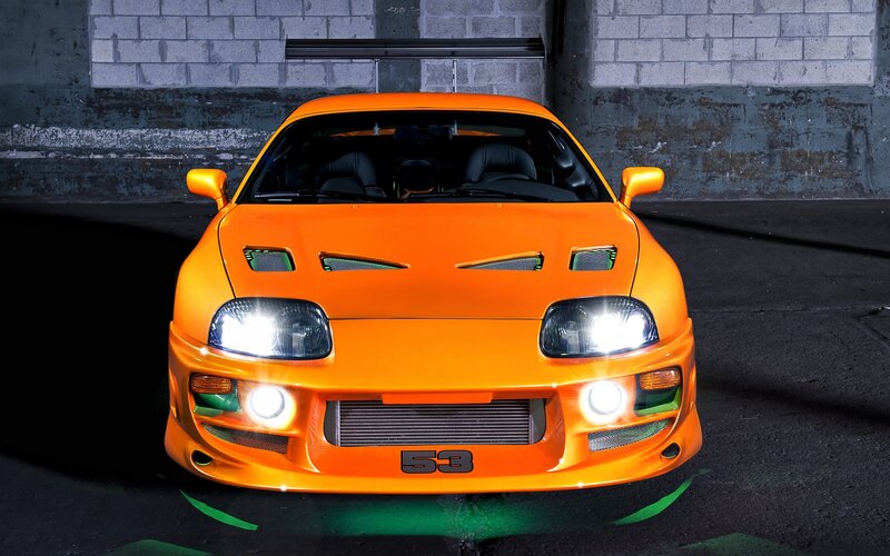 orange sports car with lights on