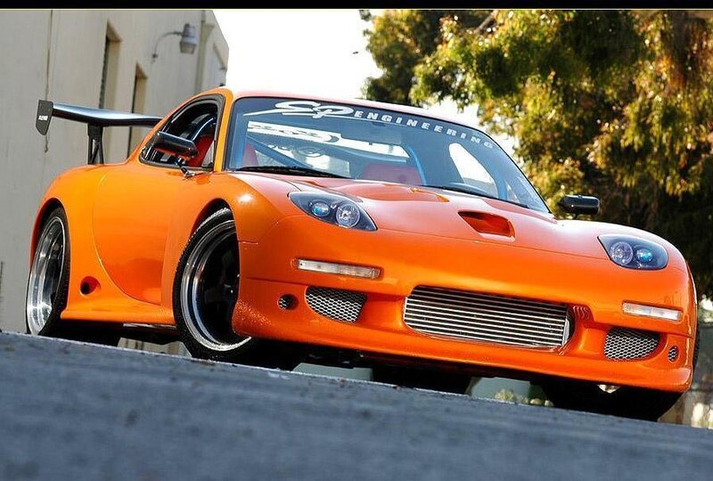 orange sports car with rear wing