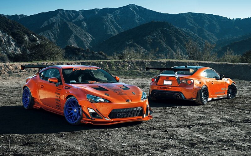 Orange sports cars in mountains