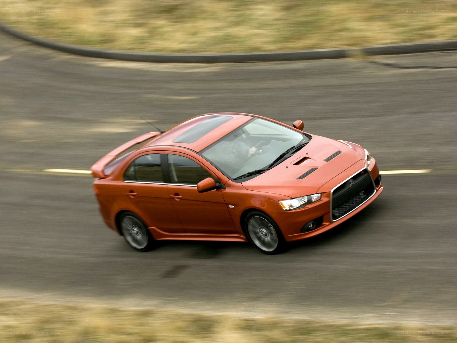 Orange sports sedan in motion