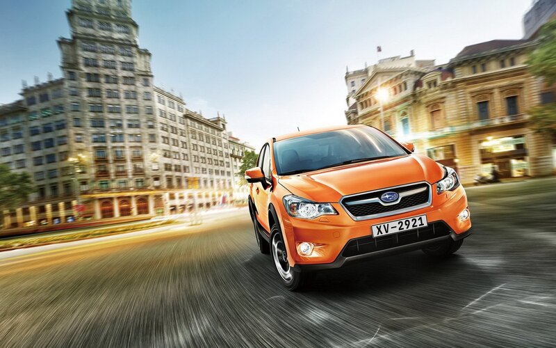 Orange Subaru driving in city