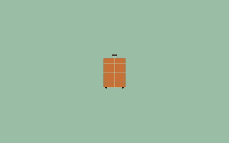 orange suitcase on green background