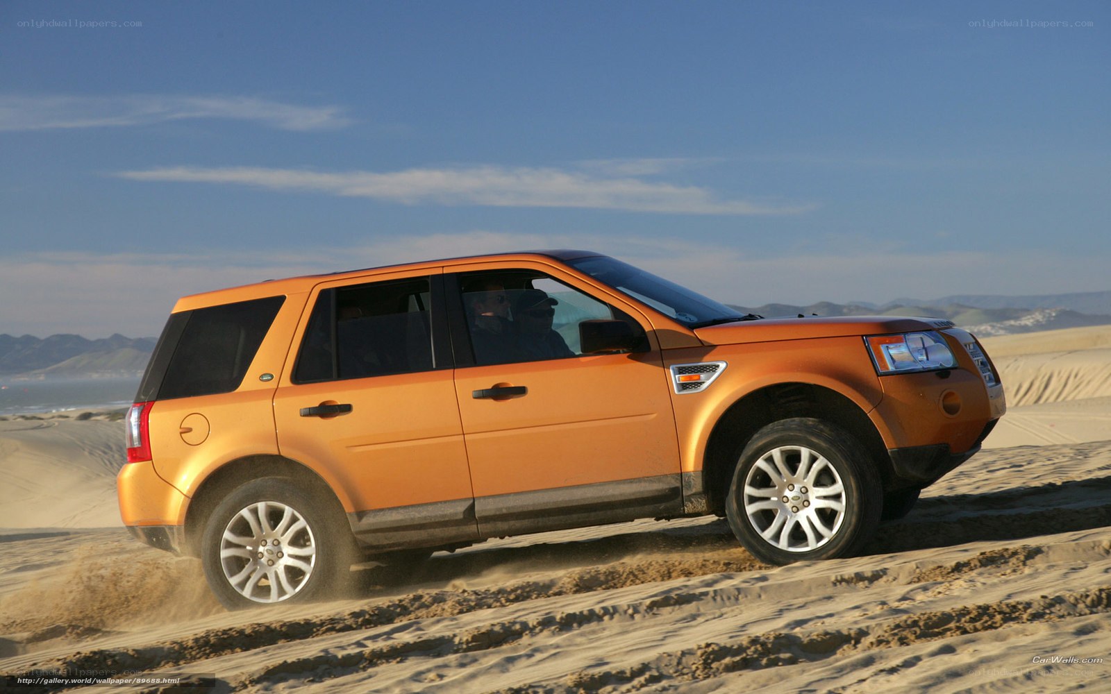orange SUV on sand dunes