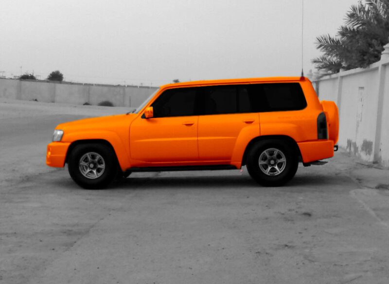 orange suv parked on pavement