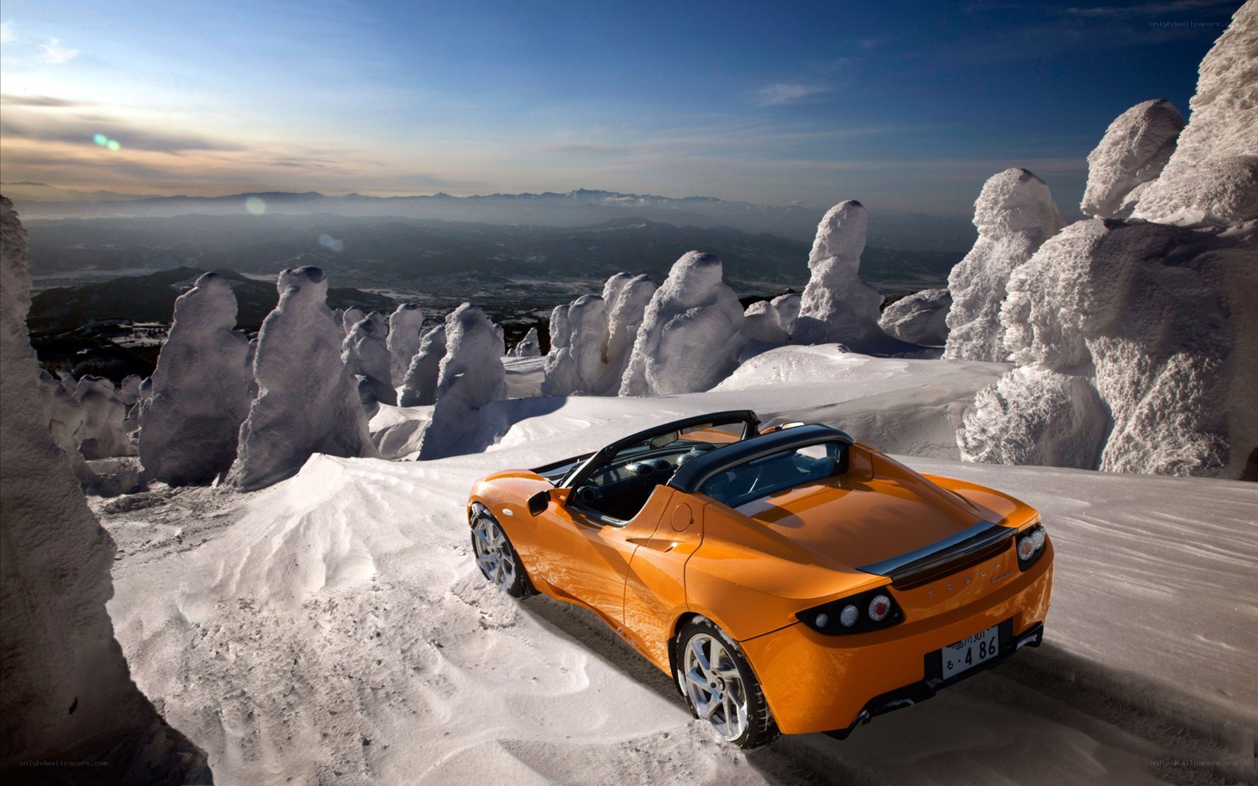 Orange Tesla Roadster on snowy mountain