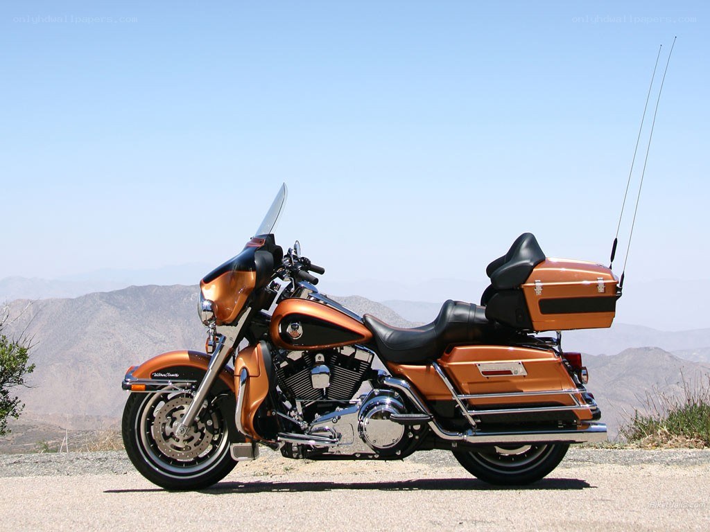 orange touring motorcycle on mountain road
