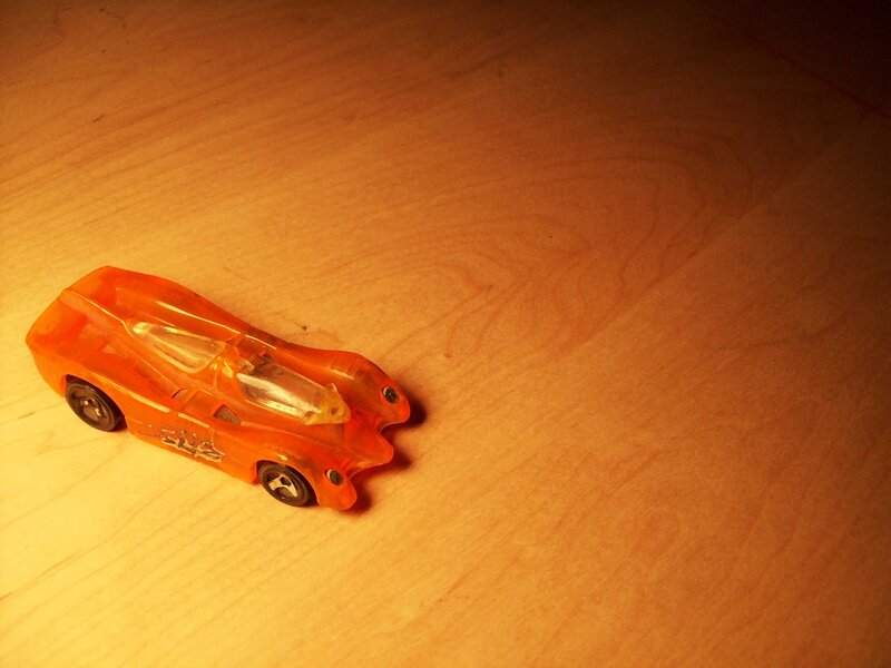 Orange toy car on wood