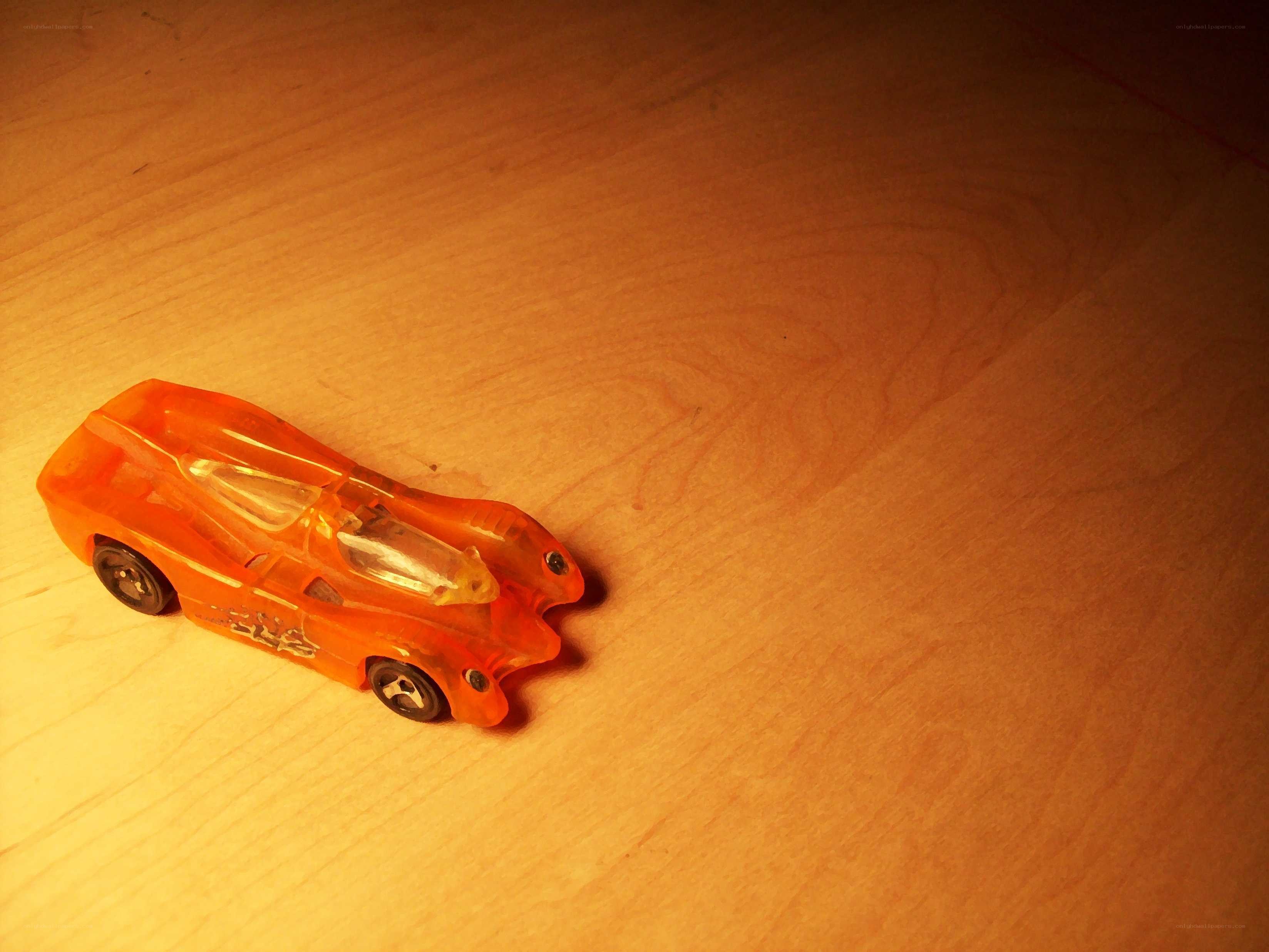 Orange toy car on wood