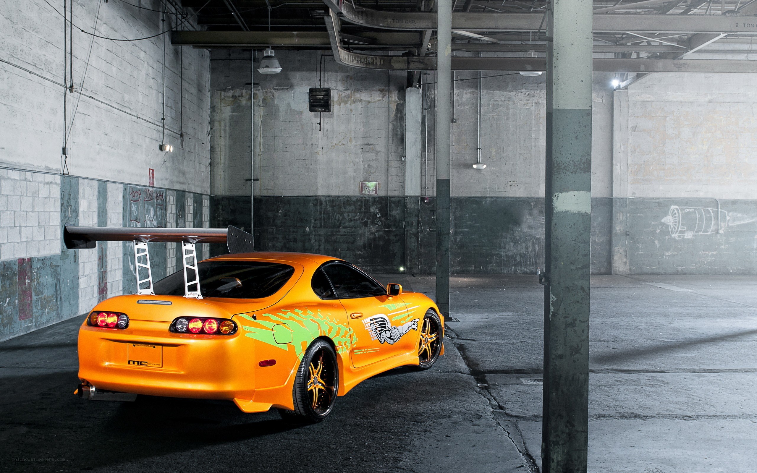 Orange Toyota Supra in warehouse