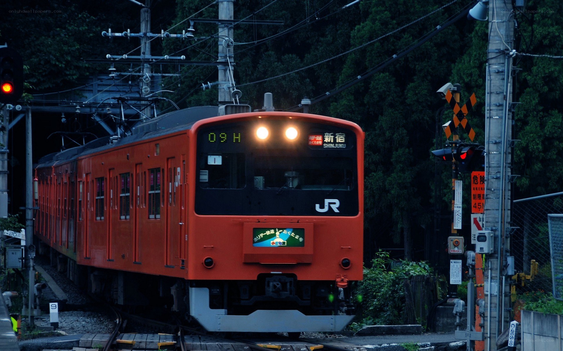 Orange train at a railway crossing