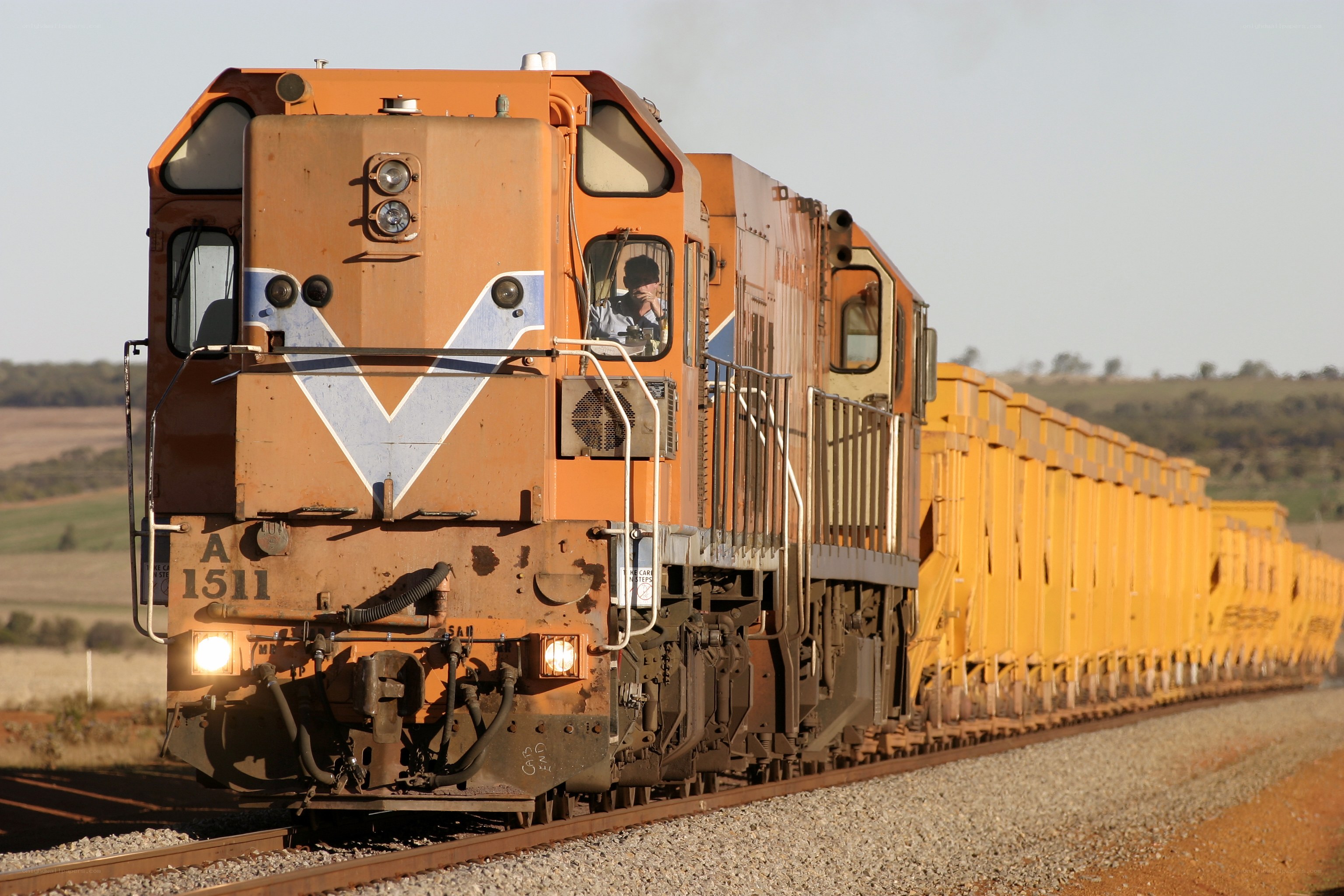 orange train on rural tracks