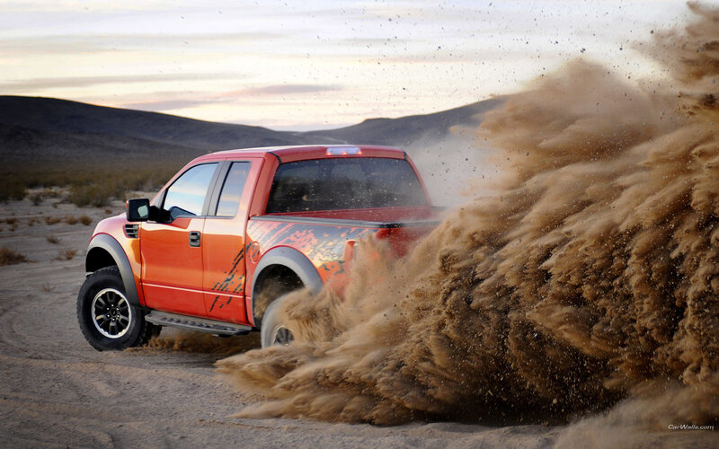 orange truck kicking up dust
