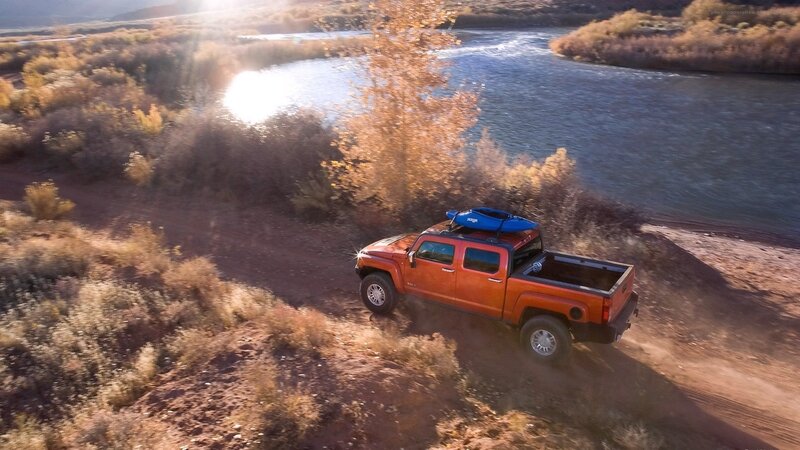 Orange truck near river at sunset