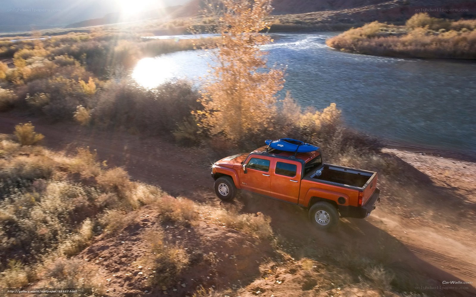 Orange truck near river at sunset