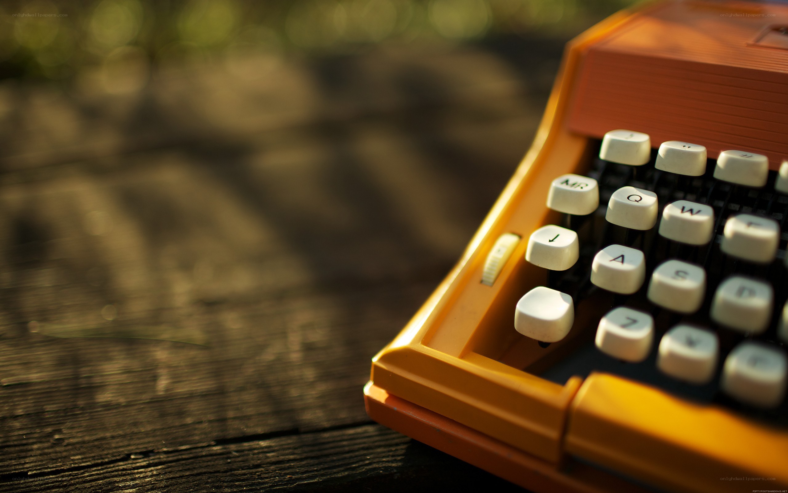 orange typewriter on wooden surface