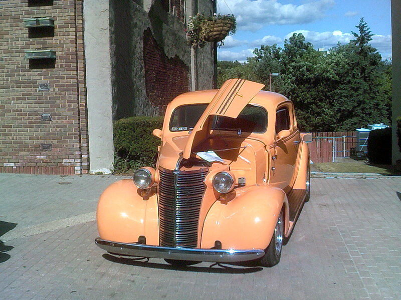 Orange Vintage Car — Calm, Afternoon, Photograph, Brick Building