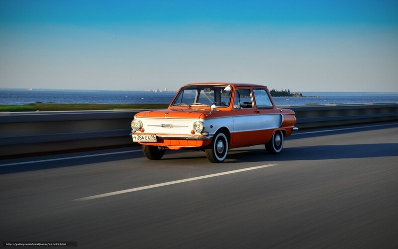Orange vintage car on coastal road