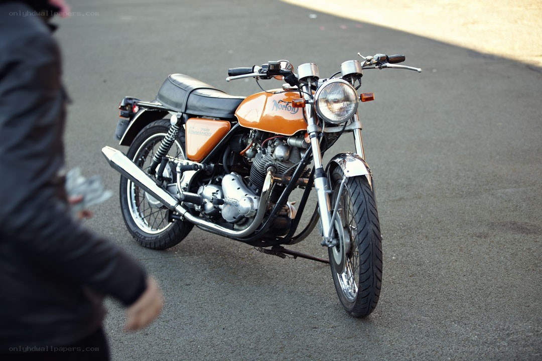 orange vintage motorcycle on pavement