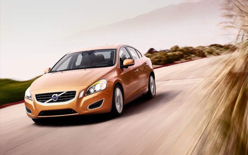 orange volvo driving on road