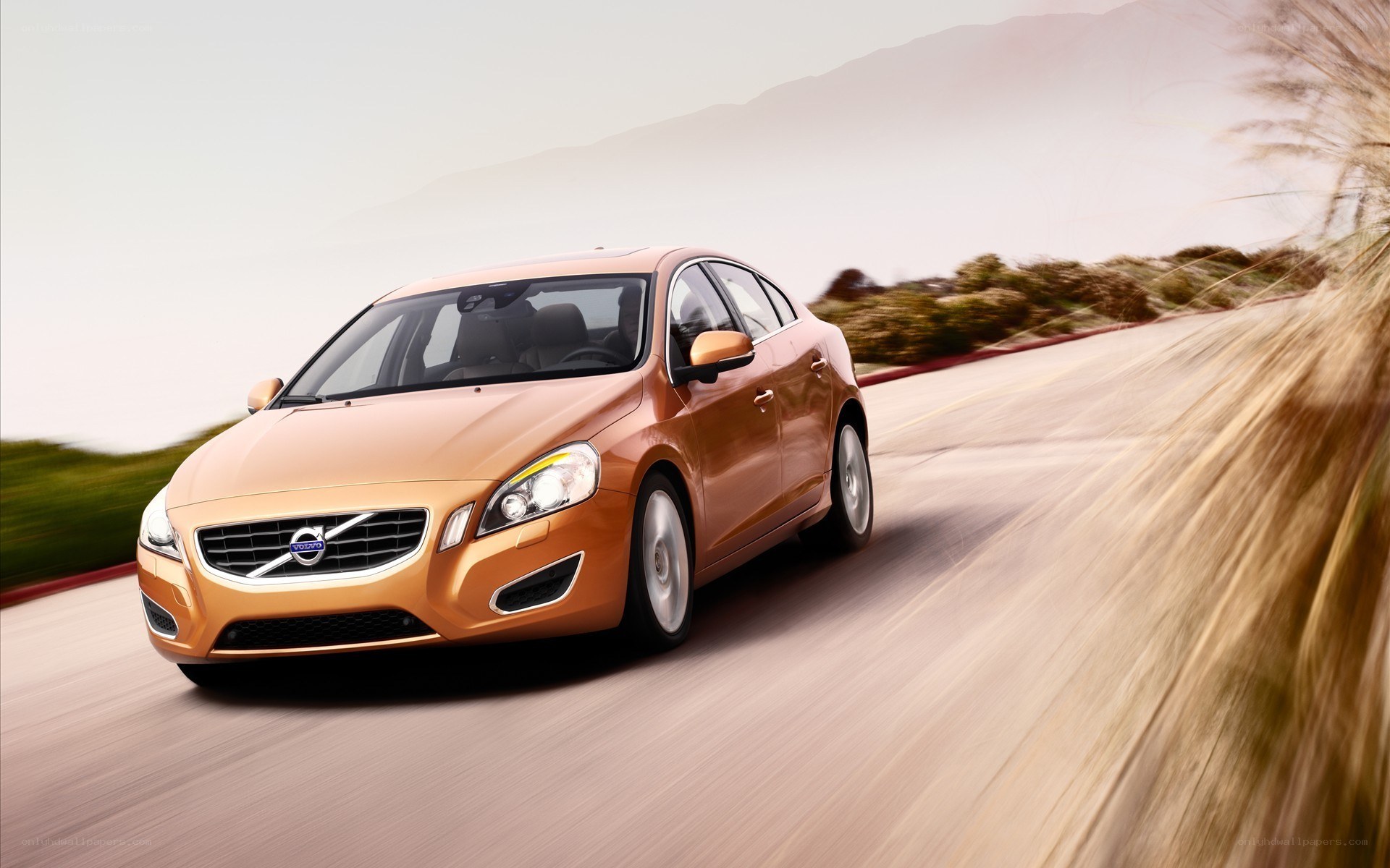 orange volvo driving on road