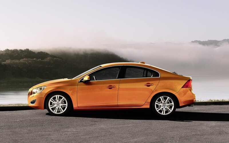 Orange Volvo sedan on a misty road