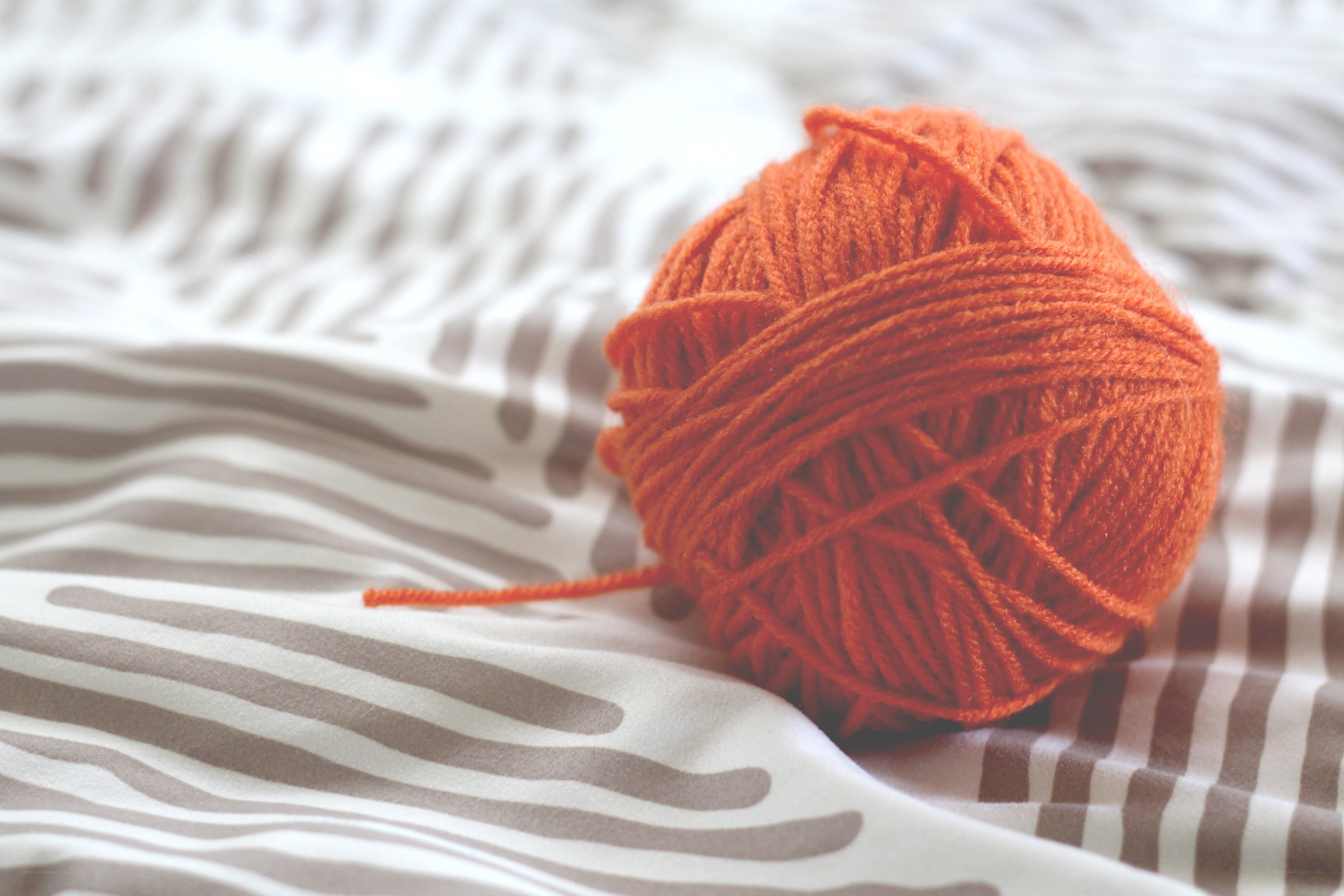 orange yarn ball on fabric
