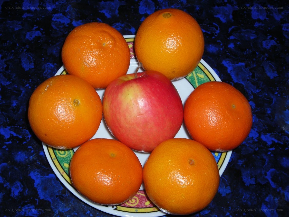 oranges and an apple on a plate