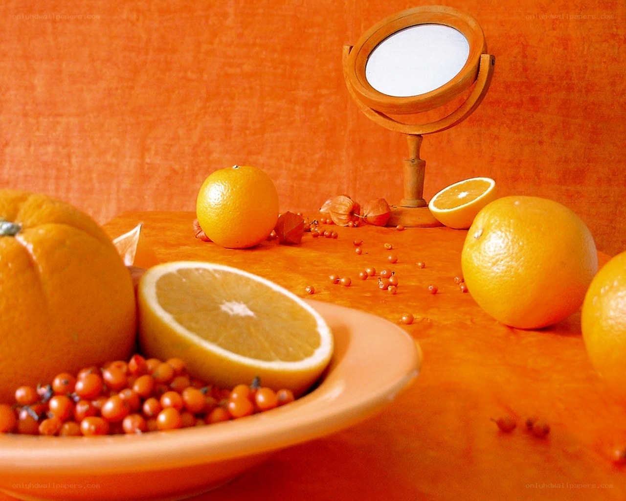 Oranges and berries on orange table