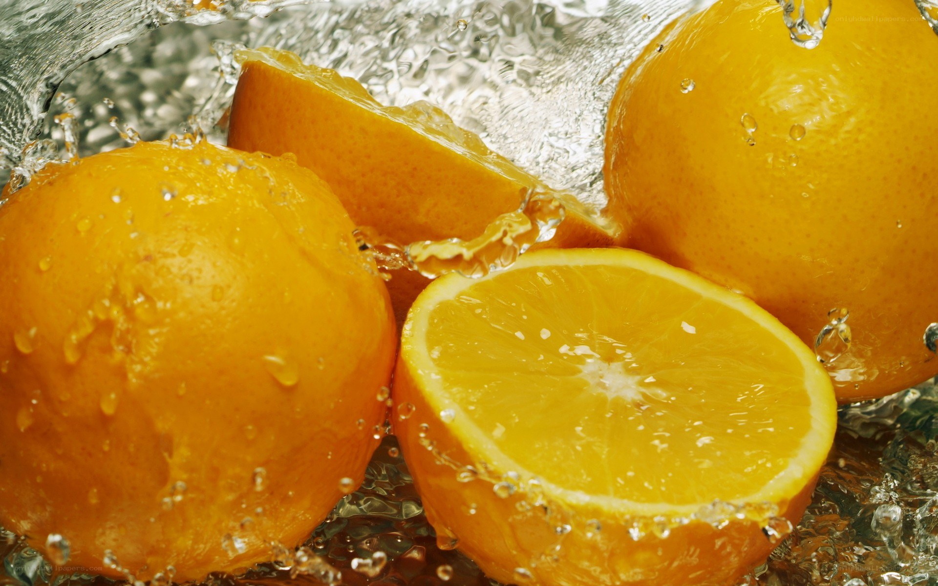 Oranges splashing in water