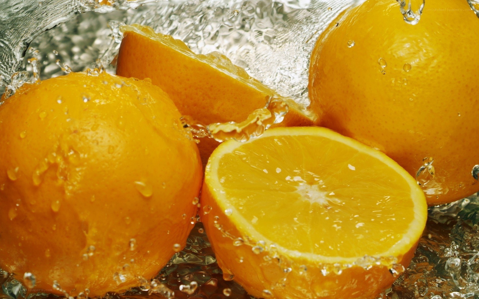 Oranges splashing in water