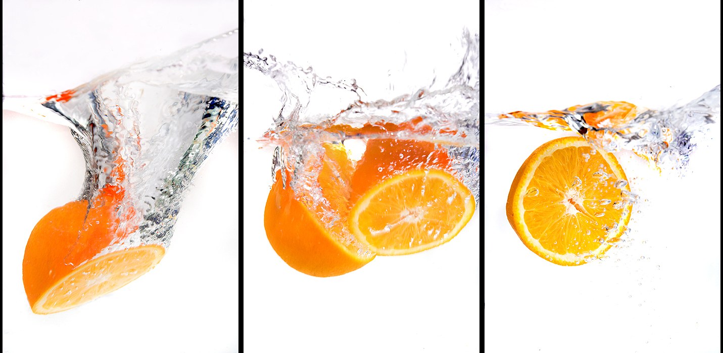 Oranges splashing in water