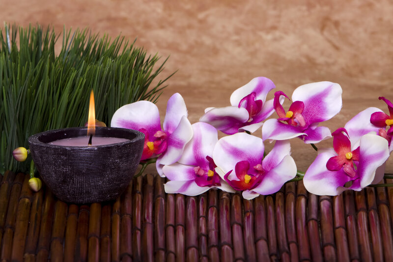 Orchids and candle on bamboo