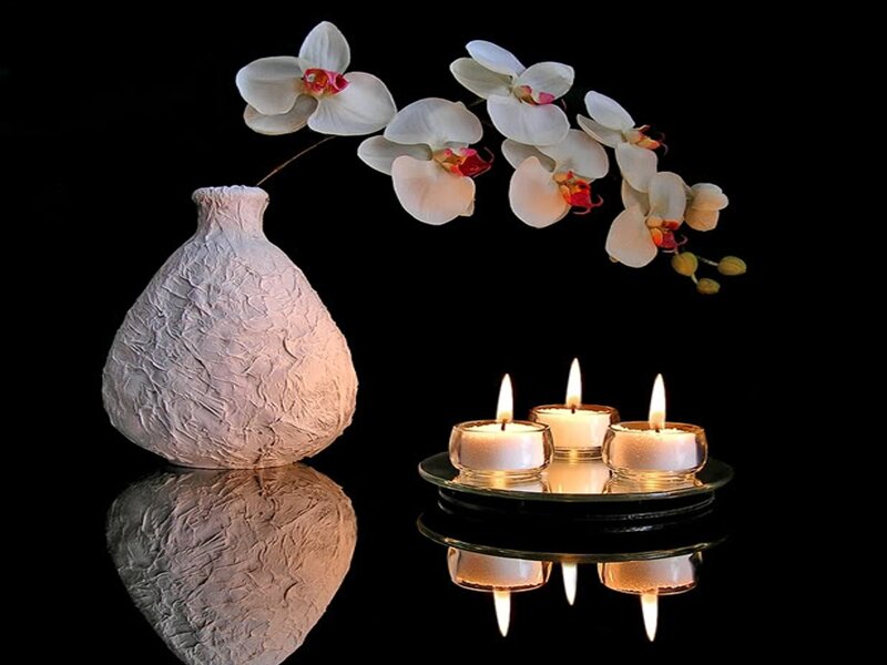 Orchids and candles on black