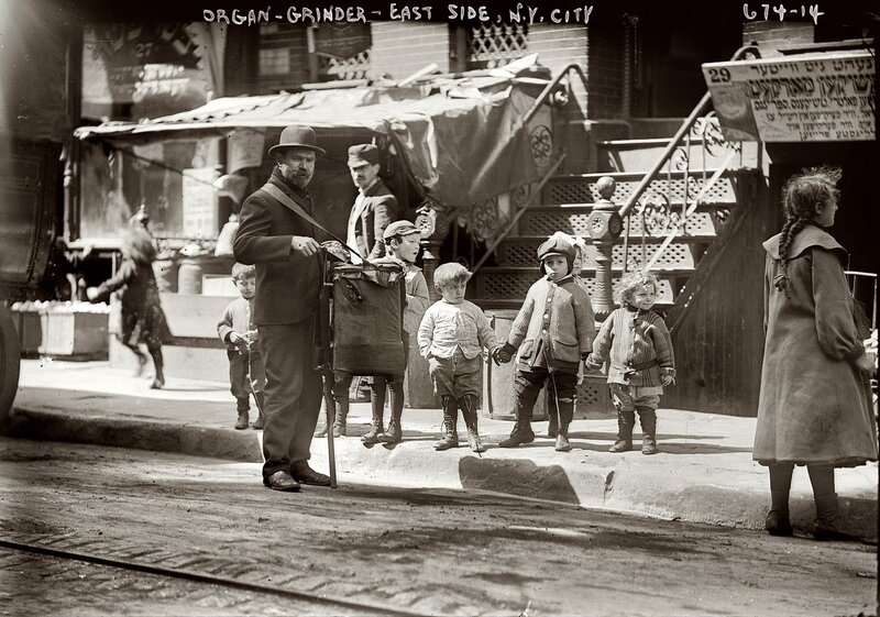 Organ grinder with children on street