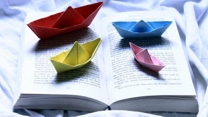 origami boats on open book