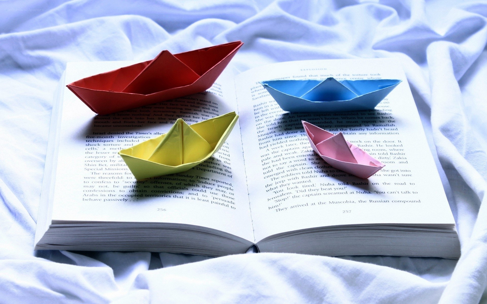 Origami boats on open book