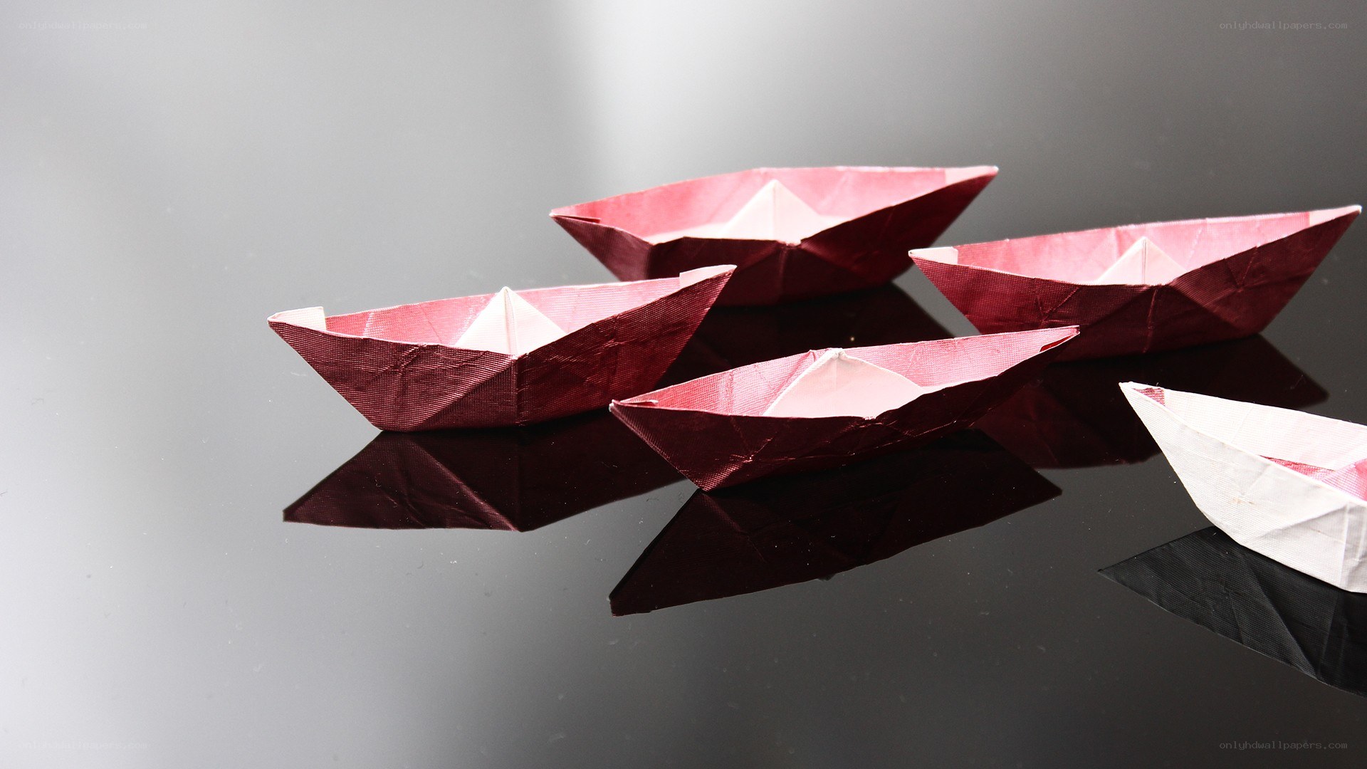 origami boats on reflective surface